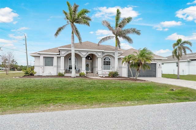 view of front of house with a front lawn, driveway, covered porch, a garage, and stucco siding