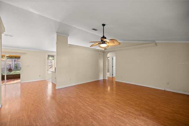 unfurnished living room with arched walkways, light wood finished floors, visible vents, a ceiling fan, and ornamental molding