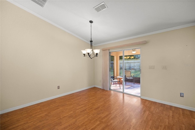 empty room with ornamental molding, wood finished floors, and visible vents