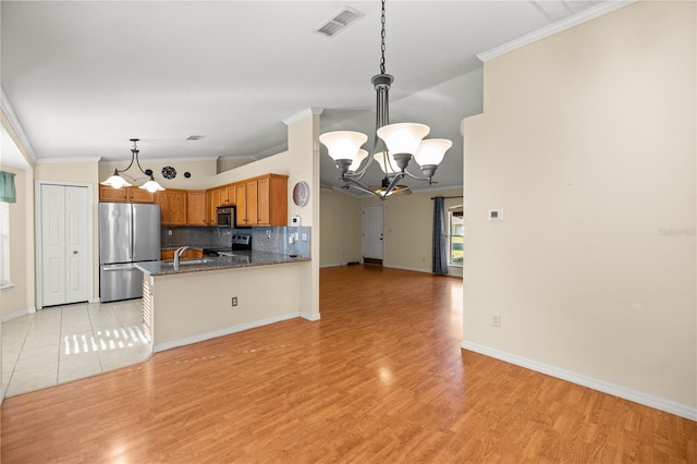 kitchen featuring visible vents, appliances with stainless steel finishes, a notable chandelier, crown molding, and backsplash