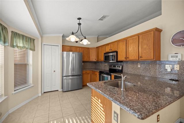 kitchen featuring visible vents, brown cabinets, a peninsula, stainless steel appliances, and a sink