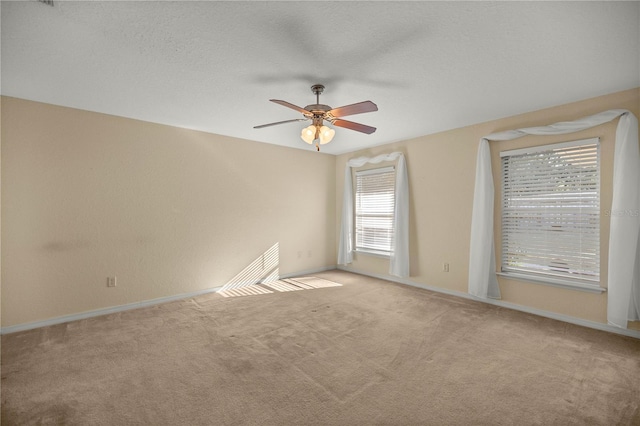 spare room featuring carpet floors, a textured ceiling, and a ceiling fan