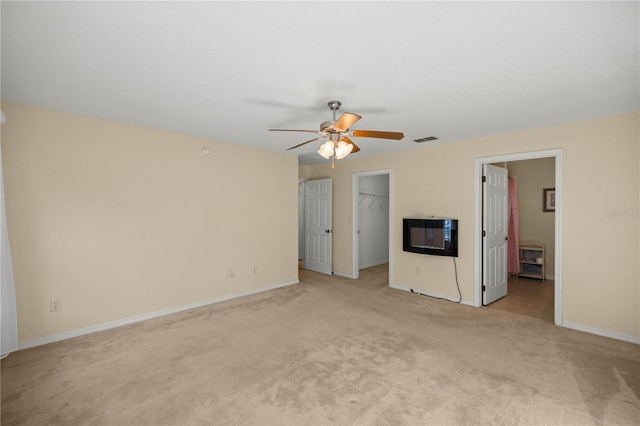 interior space with baseboards, visible vents, light colored carpet, a spacious closet, and a closet