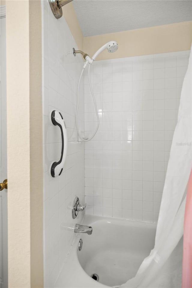 full bathroom with a textured ceiling and shower / bath combo with shower curtain