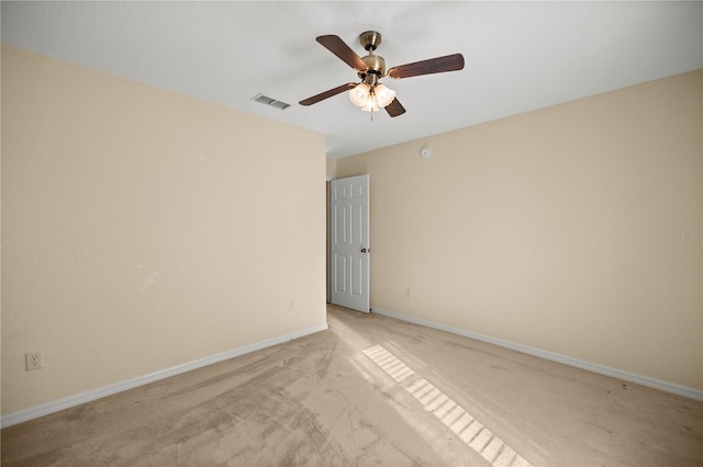 unfurnished room featuring baseboards, visible vents, ceiling fan, and light colored carpet