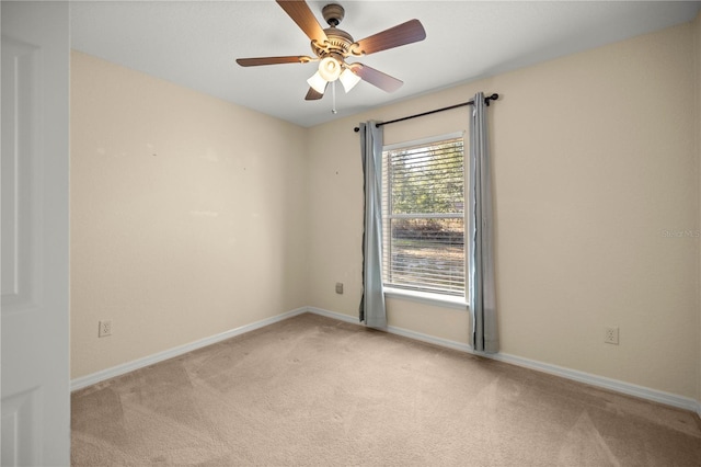 spare room featuring carpet, baseboards, and a ceiling fan