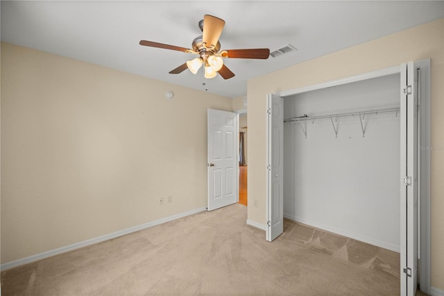 unfurnished bedroom featuring a closet, visible vents, a ceiling fan, light carpet, and baseboards