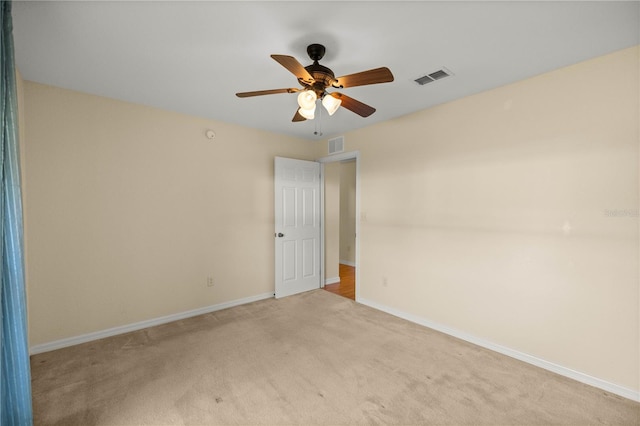 spare room featuring a ceiling fan, carpet, visible vents, and baseboards