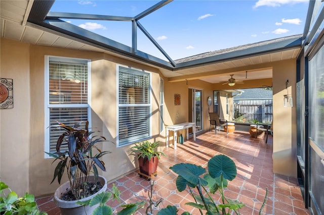 view of patio featuring a lanai, ceiling fan, and fence