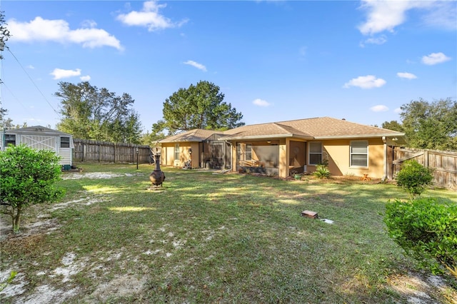 rear view of house with a sunroom, a fenced backyard, a yard, and stucco siding