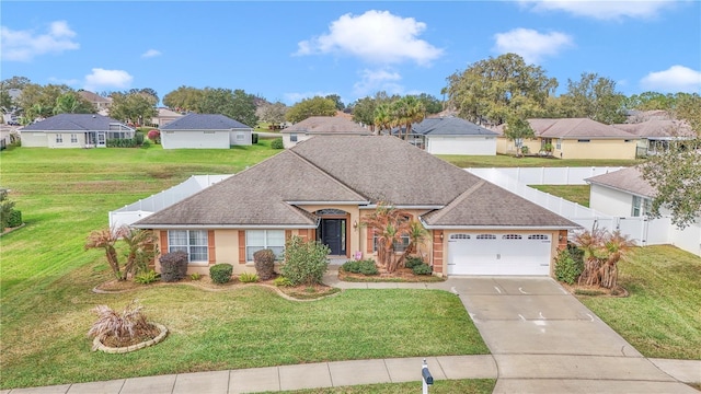 single story home featuring a residential view, concrete driveway, an attached garage, and a front yard