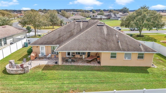 back of property with a yard, a patio, stucco siding, a residential view, and a fenced backyard