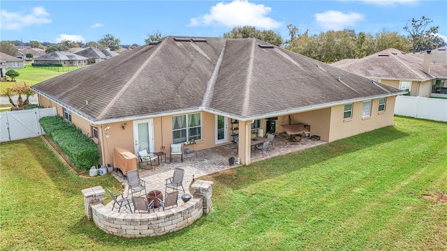 back of property with a fire pit, a patio area, a fenced backyard, and stucco siding