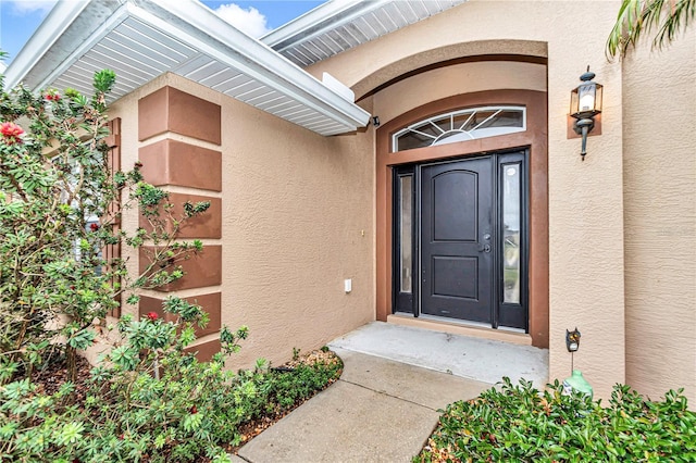 view of exterior entry featuring stucco siding