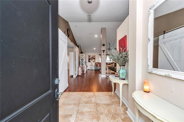 foyer with light tile patterned floors and a barn door