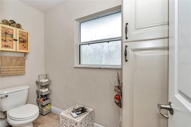 bathroom with tile patterned flooring, baseboards, and toilet