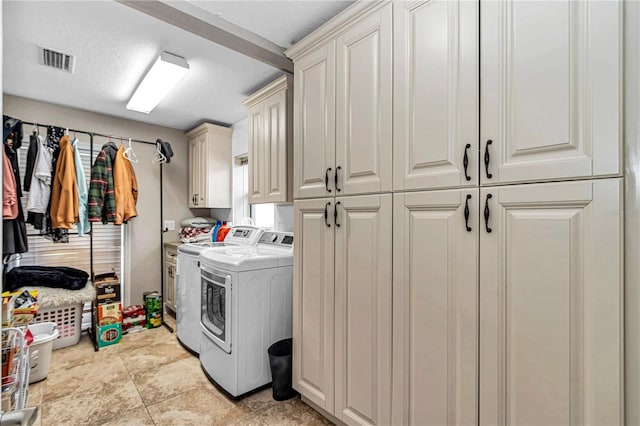 washroom featuring cabinet space, visible vents, and washing machine and clothes dryer