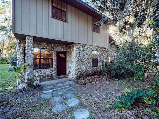 view of front of home featuring stone siding and central AC unit