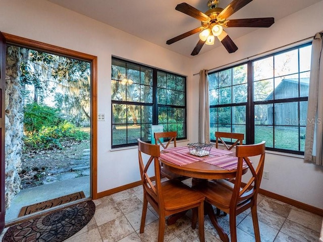 dining space with a wealth of natural light, ceiling fan, and baseboards