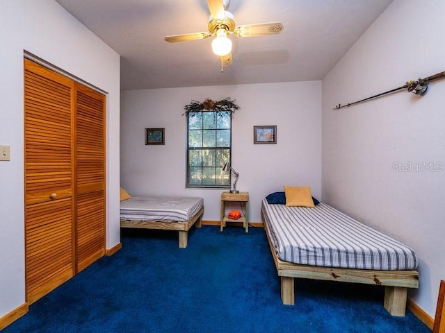 carpeted bedroom featuring a ceiling fan, a closet, and baseboards