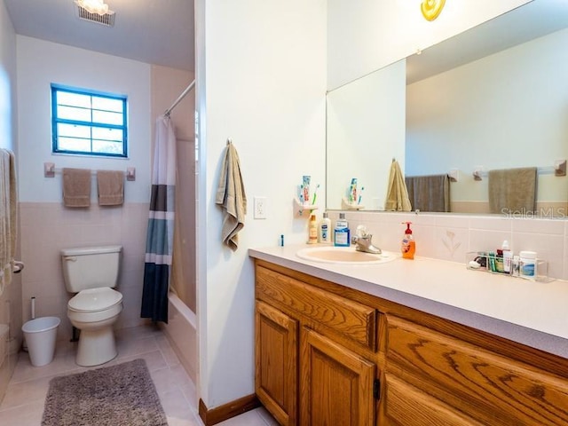 full bath featuring toilet, tile walls, vanity, visible vents, and tile patterned floors