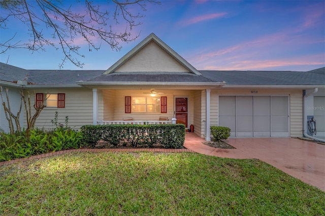 view of front of property featuring driveway, a yard, and an attached garage