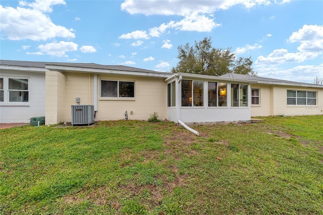 rear view of property featuring a sunroom, a lawn, and central air condition unit