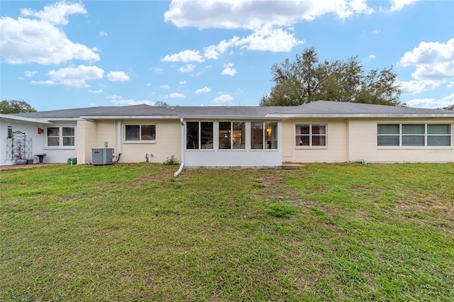 back of house with central AC and a lawn