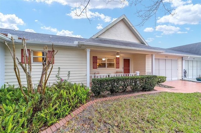 view of front of house with an attached garage, a front lawn, and a porch