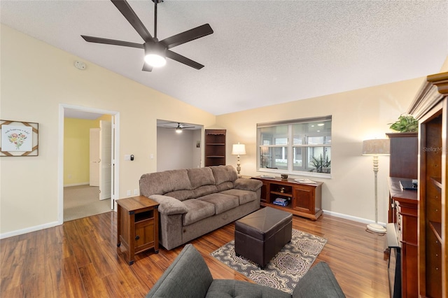 living area featuring lofted ceiling, dark wood-style flooring, ceiling fan, and a textured ceiling