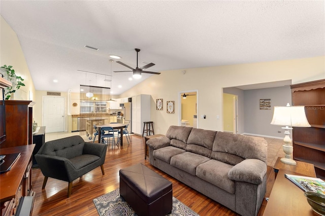 living room featuring visible vents, a ceiling fan, vaulted ceiling, a textured ceiling, and wood finished floors