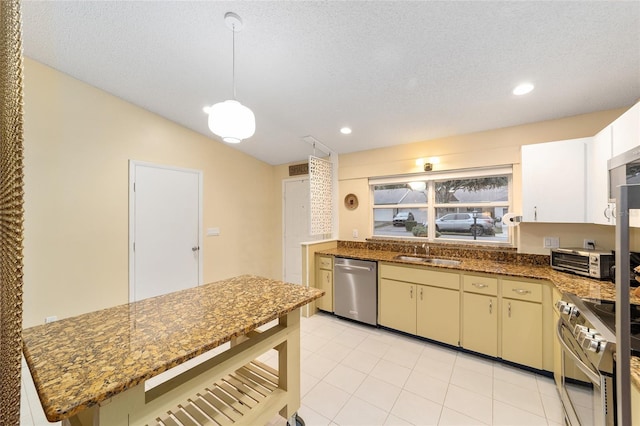 kitchen with lofted ceiling, appliances with stainless steel finishes, dark stone counters, and a sink