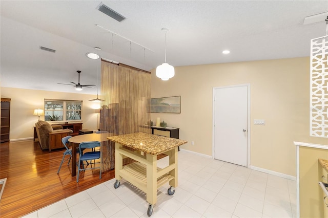 kitchen with open floor plan, visible vents, and baseboards