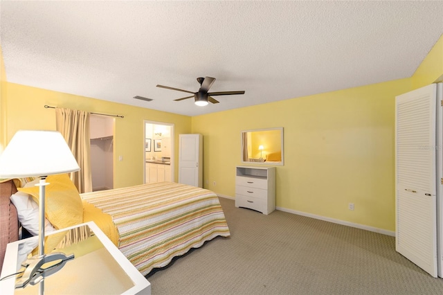 bedroom with baseboards, visible vents, light colored carpet, a textured ceiling, and a closet