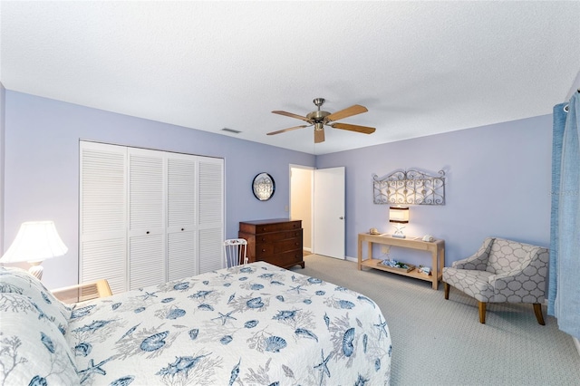 bedroom featuring a textured ceiling, a closet, carpet flooring, and visible vents