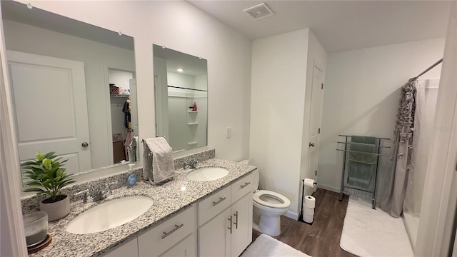 bathroom featuring a shower with curtain, visible vents, a sink, and wood finished floors