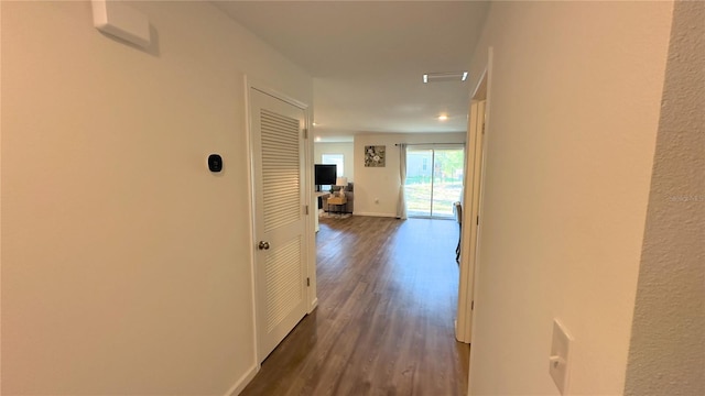 hallway featuring dark wood finished floors and baseboards