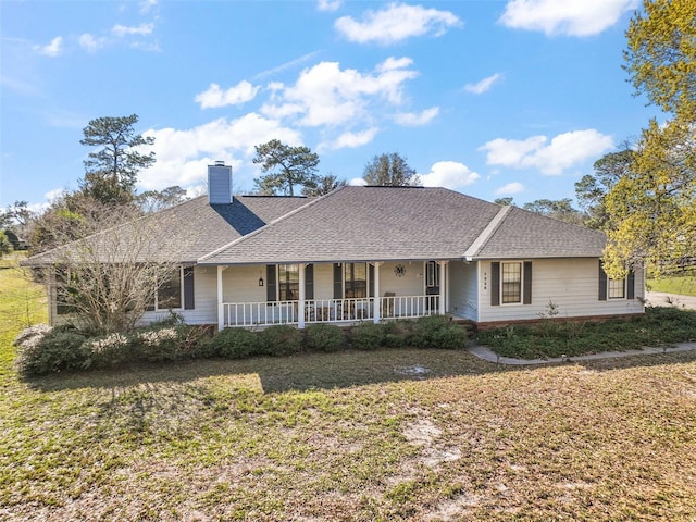 ranch-style home featuring a shingled roof, a chimney, a porch, and a front yard