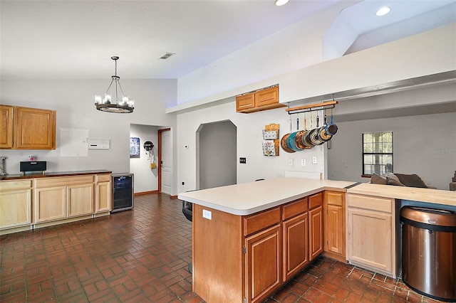 kitchen featuring lofted ceiling, beverage cooler, light countertops, and a peninsula