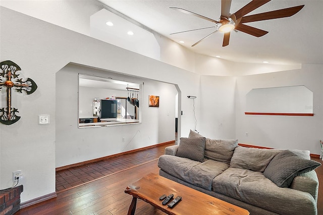 living area with arched walkways, baseboards, vaulted ceiling, and dark wood-style flooring