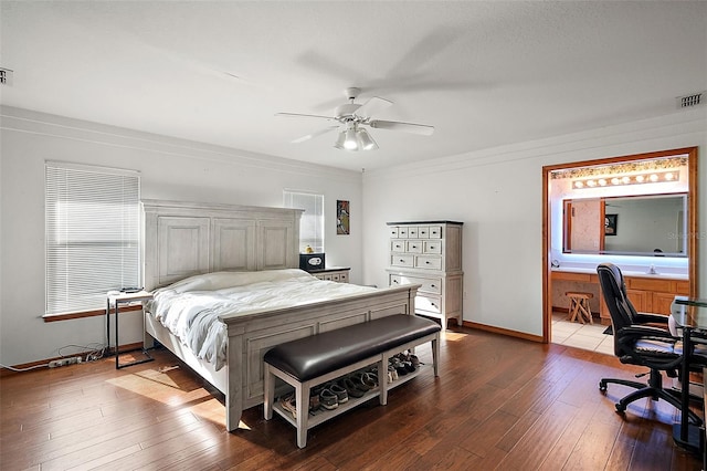 bedroom with baseboards, wood-type flooring, ceiling fan, ensuite bathroom, and crown molding