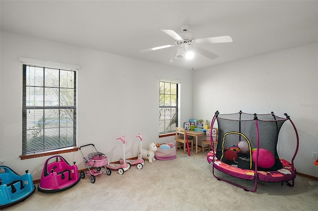 recreation room featuring a ceiling fan and light colored carpet