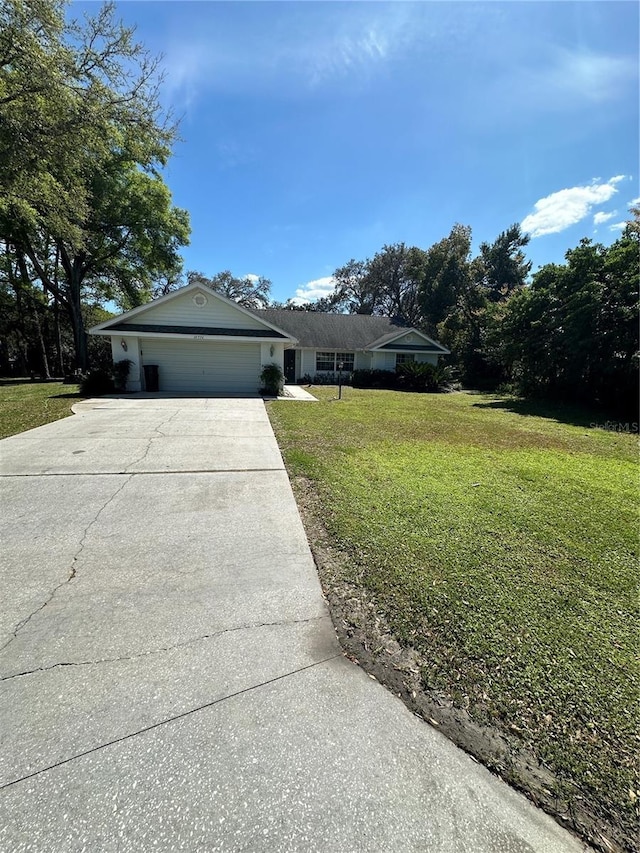 ranch-style home featuring a garage, concrete driveway, and a front lawn