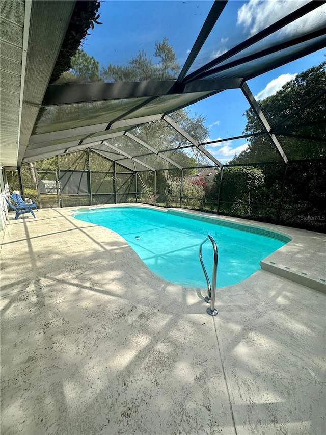 outdoor pool with a lanai and a patio area