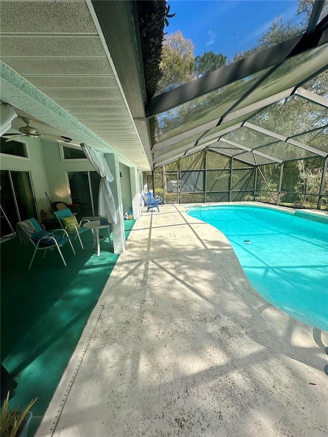 pool with a lanai, a patio area, and ceiling fan