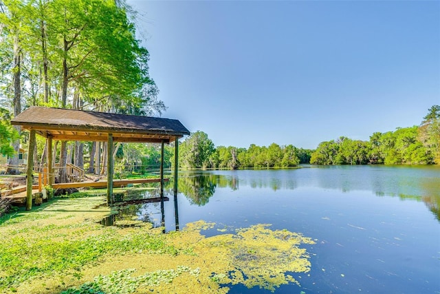 view of dock with a water view and a wooded view