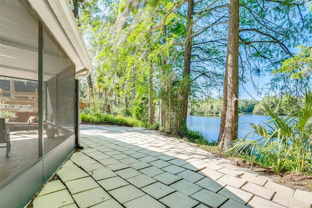 view of patio / terrace featuring a water view and a sunroom