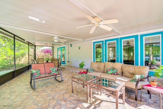 sunroom featuring beam ceiling and a ceiling fan