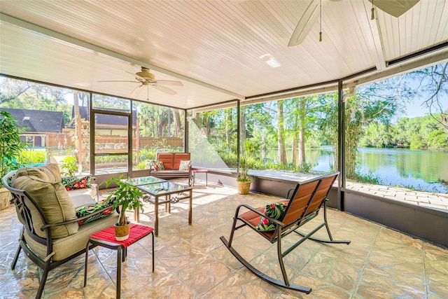 sunroom / solarium with a water view and a ceiling fan