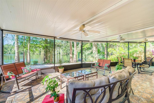 sunroom featuring plenty of natural light, a water view, and a ceiling fan